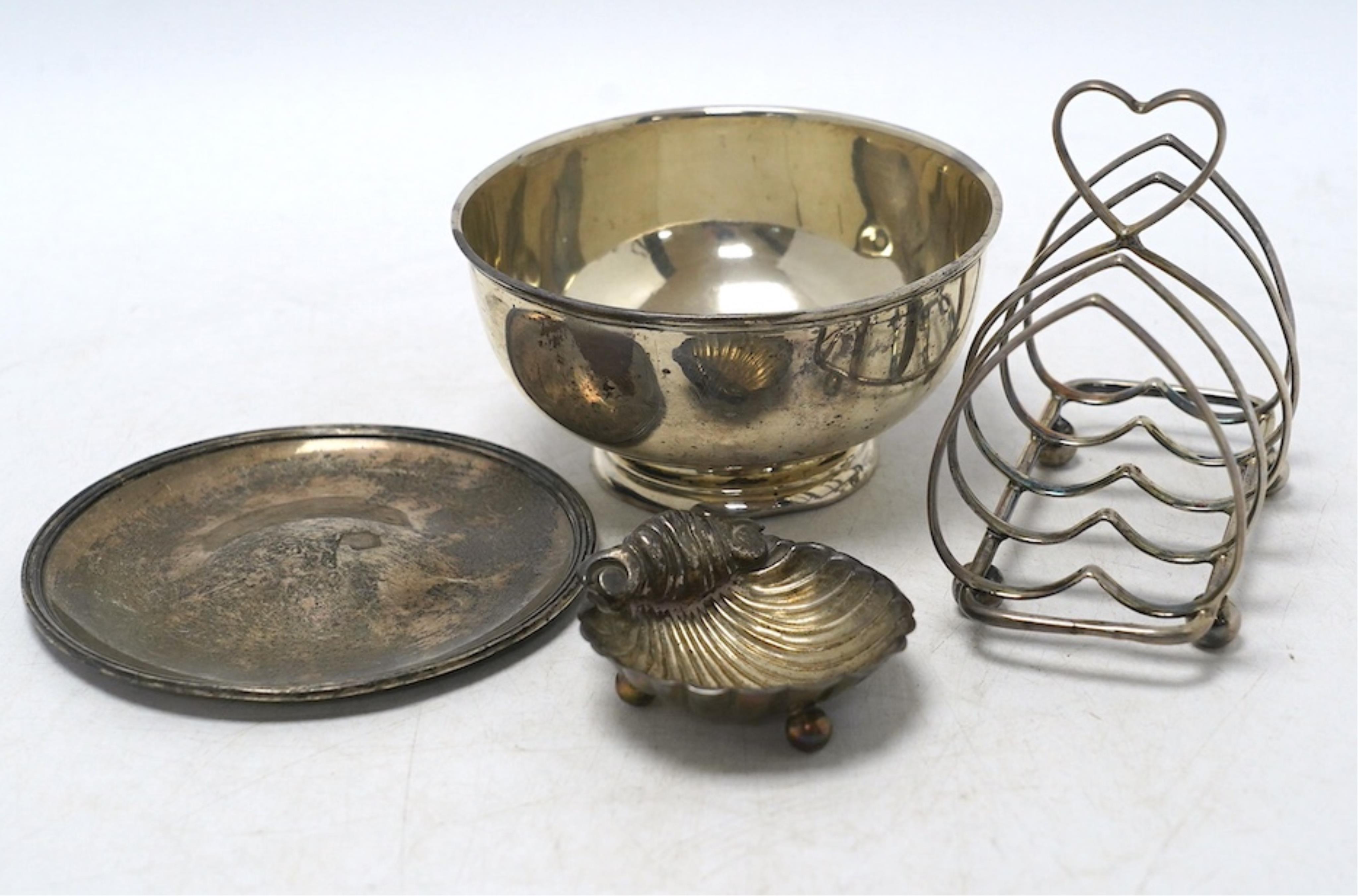 An Edwardian silver five bar toast rack, 96mm, together with a silver sugar bowl, a small silver dish and a silver shell salt, 8.3oz. Condition - fair